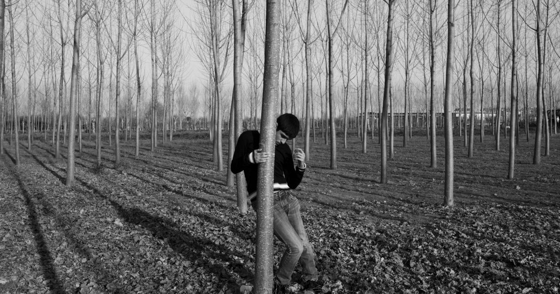 Italy, Casal di Principe (CE), 12/03/2014. Gennaro, one of the two autistic twins, spends an afternoon in the family poplar grove. The boy clings to the tree and has a stereotype because the open space destabilizes him.